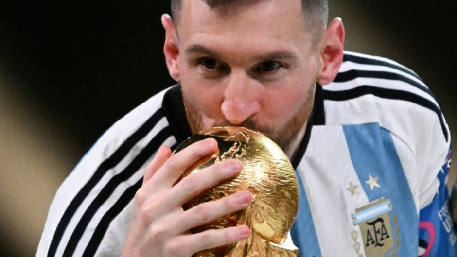 Lionel Messi kisses the World Cup trophy after winning the 2022 final against France in Doha