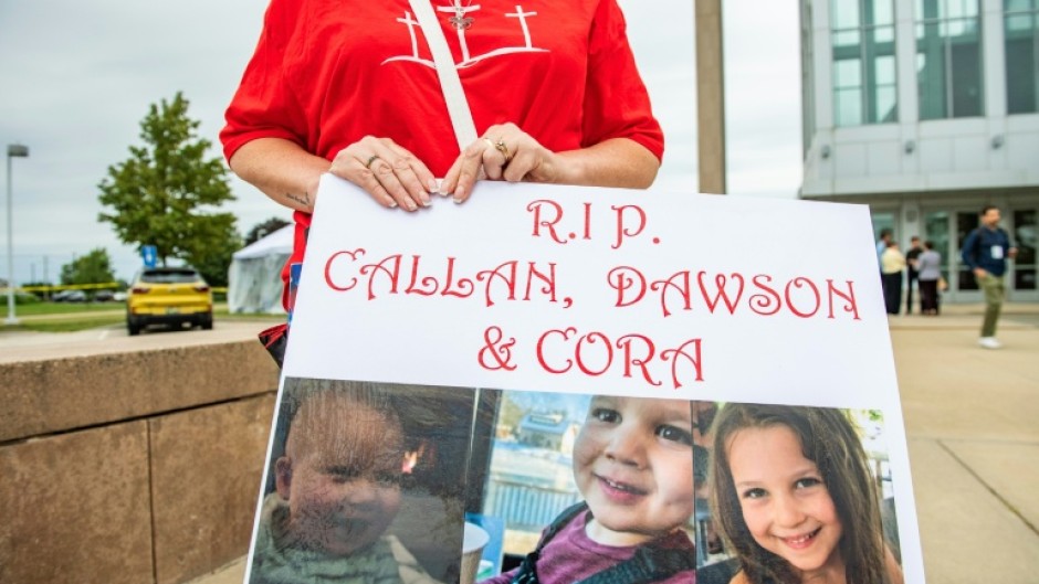 A woman carries a sign to show support for the three children of Lindsay Clancy during her murder trial in Plymouth, Massachusetts