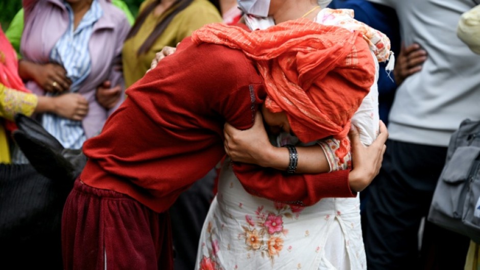 People mourn their missing relatives in the aftermath of flash floods, outside a mortuary in Nepal's Chitwan district