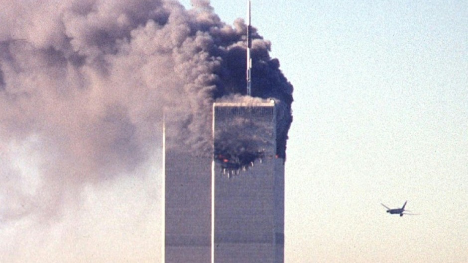 United Airlines Flight 175 is seen approaching the south tower of the World Trade Center as smoke billows from the north tower in New York on September 11, 2001
