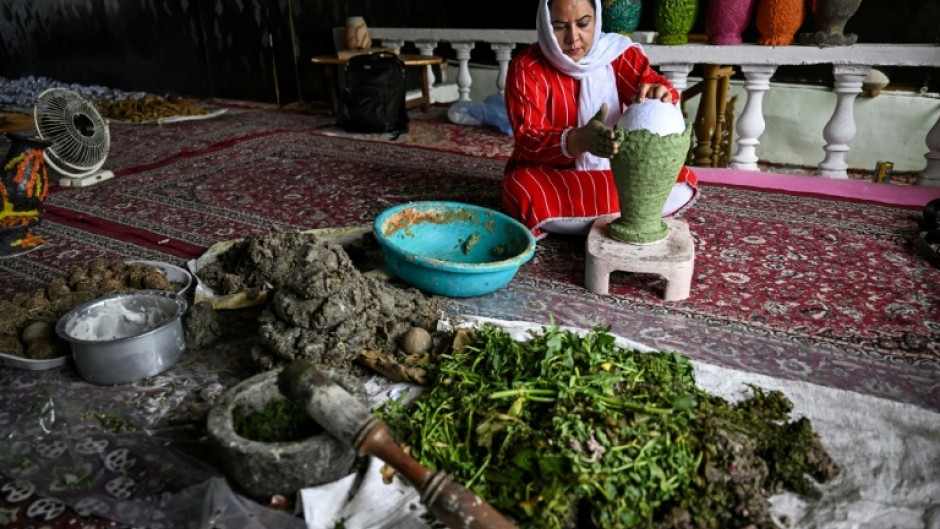A Kashmiri artisan uses dried aquatic weeds and grass collected from Dal Lake to create sustainable handcrafted papier-mache at a workshop in Srinagar on August 19, 2026