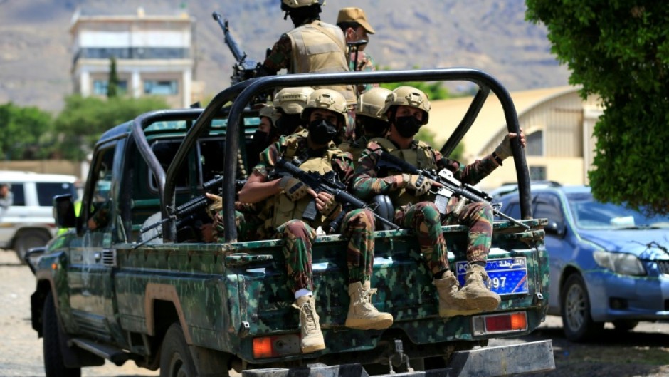 Yemen's Houthi armed forces patrol as Yemeni prisoners loyal to the Houthi authorities arrive in the capital Sanaa on September 12