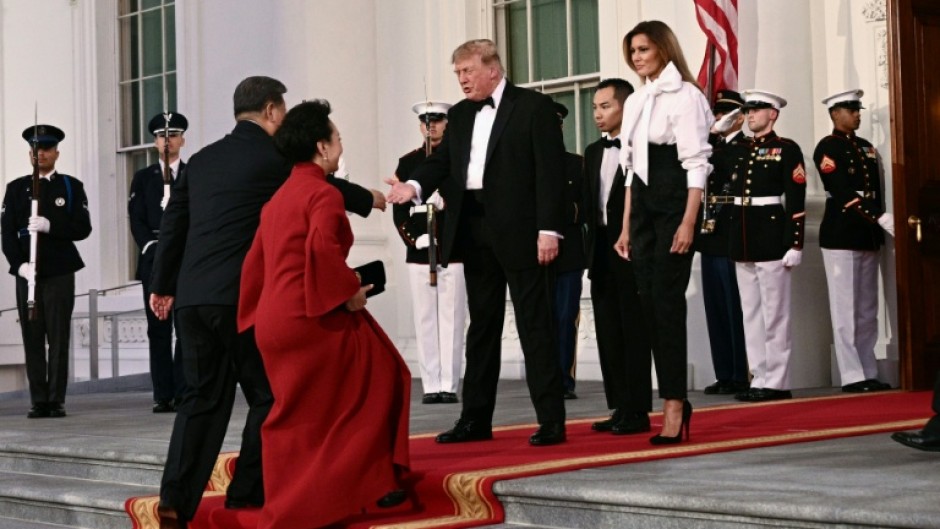 US President Donald Trump and First Lady Melania Trump greet China's President Xi Jinping and his wife Peng Liyuan upon their arrival at the White House for a state dinner