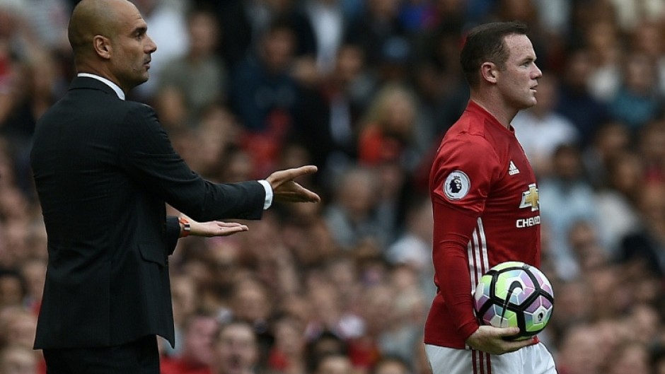 Former Manchester United striker Wayne Rooney (R) stands next to ex-Manchester City boss Pep Guardiola
