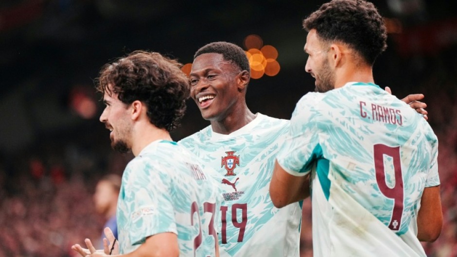Portugal players celebrate after scoring one of their goals in a 4-2 victory away to Denmark