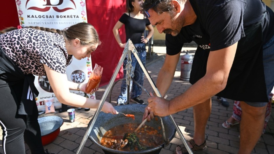 Teams competing in a cooking contests poured generous amounts of paprika into their cauldrons