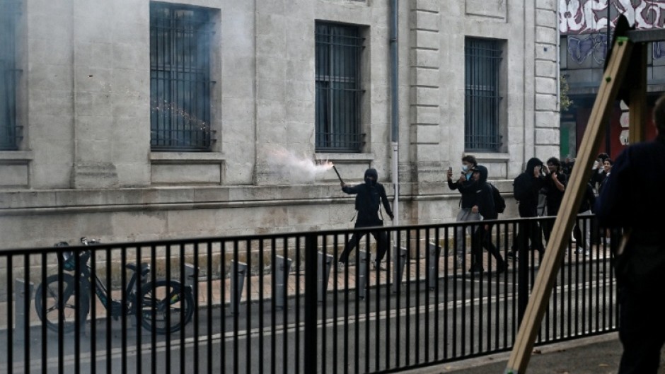 A protester holds a firework stick during protests in the soutwestern town of Bordeaux