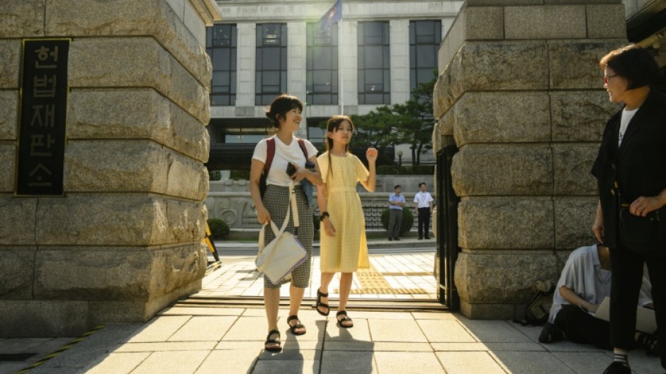 Young climate activist Han Jeah and her mother, Kim Eun-jae, celebrate outside South Korea's Constitutional Court after their victory in August 2024, which forced the government to set new targets for reducing greenhouse gas emissions