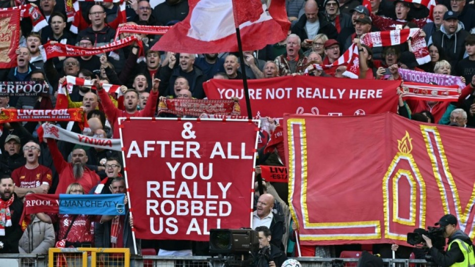 Liverpool fans hold signs mocking Manchester City's financial scandal