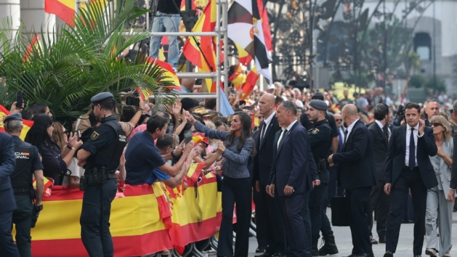 Spain's Queen Letizia shakes hands with people lining the streets of Ceuta