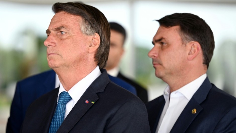 Jair Bolsonaro (L) remains the leader of his political movement in Brazil and selected Flavio Bolsonaro (R) to run for president in his place