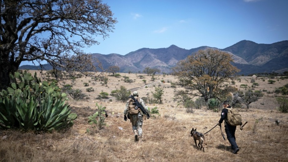 A Mexican soldier and a member of a search team look for a missing person in Tepotzotlan in Mexico State in March 2026