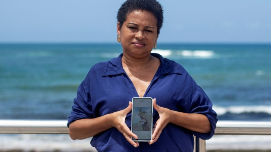 Vilma Alves de Oliveira holds the last photo she has with her son, who she claims was killed by police three years ago