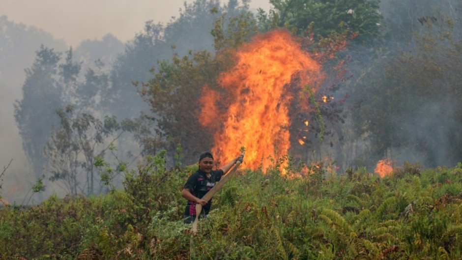 A firefighter extinguishing a fire at Sungai Tabuk village in Indonesia's Kalimantan Province on October 16