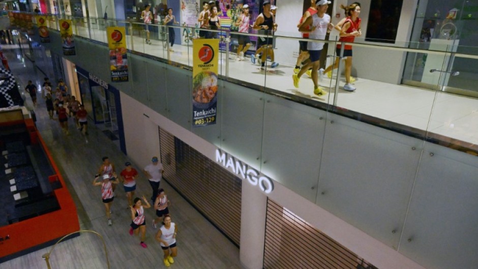 Fitness enthusiasts run inside a Singapore mall
