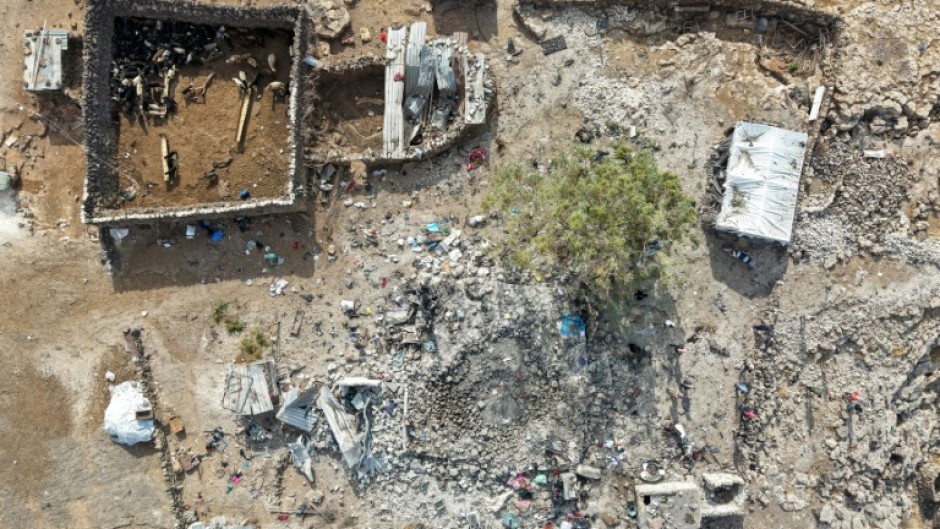 People inspecting the damage at a site targeted by airstrikes