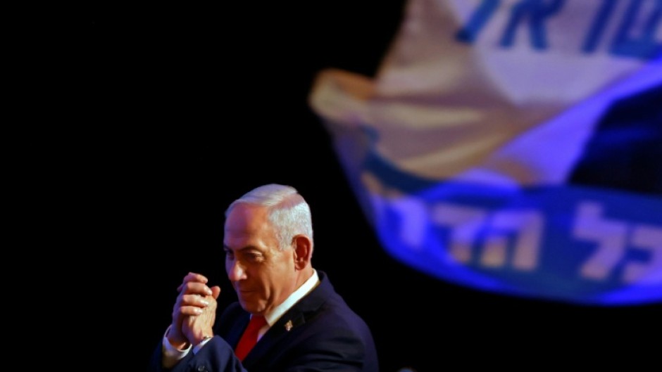 Israel's Prime Minister Benjamin Netanyahu gestures to his supporters at an election night rally after the first exit polls were announced, in Jerusalem