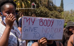 File: A protester holds a placard during a GBV protest.AFP/Hildegard Titus