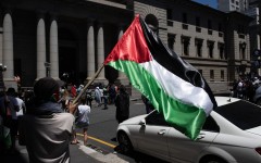 A man holds a Palestinian flag as they take part in a pro-Palestinian demonstration outside the High Court in Cape Town on January 11, 2024. Dozens of people took to the streets in Cape Town on on January 11, 2024 in one of several demonstrations planned across South Africa in support of the government’s landmark "genocide" case against Israel. 