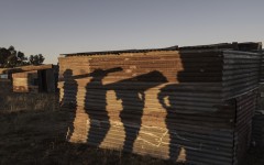 Shadows of would-be residents carrying construction materials are cast on a shack in the area where structures have been erected. AFP/Marco Longari