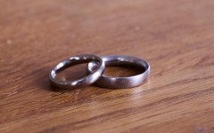 A pair of wedding rings lie on a wooden table. Annette Riedl/dpa Picture-Alliance via AFP