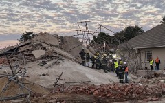 Rescue workers are seen at the scene of a collapsed building in George on May 7, 2024.