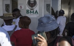 Zimbabwean migrants wishing to enter South Africa queue at a passport check before the immigration offices at the Beitbridge crossing. AFP/Marco Longari