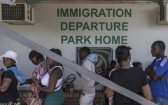 File: Zimbabwean migrants wishing to enter South Africa queue at a passport check before the immigration offices at the Beitbridge crossing. AFP/Marco Longari