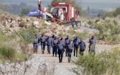 SAPS officers walk near a Metalliferous Mobile Rescue Winder during a rescue operation in Stilfontein. AFP/Christian Velcich