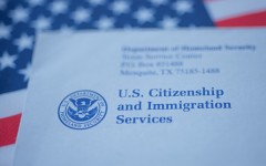 A US citizenship letter from USCIS on a USA flag. GettyImages/Evgenia Parajanian