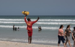 A lifeguard directs people to move into the swimming zone. AFP/Rodger Bosch