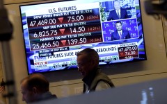 A television displaying market statistics is displayed as traders work on the floor of the NYSE. AFP/Timothy A Clary