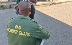 A border guard checking a woman's credentials. eNCA