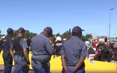 Police officers keeping an eye on demonstrators outside the Buthelezi Mall.