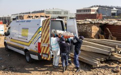10 June_South African Police Service (SAPS) officers, along with forensic technicians, carry a victim’s body into a forensic pathology service vehicle at Jumpers informal settlement in Cleveland, east of Johannesburg, on June 10, 2026.