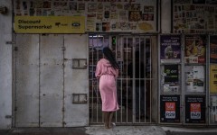 File: A resident wearing a bathrobe buys last minutes goods from a half closed shop. AFP/Marco Longari