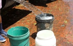 Buckets being filled with water from a water tanker.