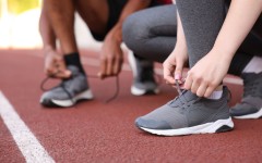 File:  Runners tying shoelaces of their sneakers. GettyImages/Olga Yastremska