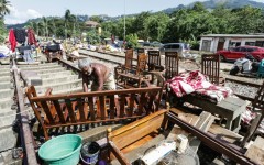 A Sri Lankan flood victim sorts out his belongings by railway tracks in Kandy. The authorities have issued fresh landslide warnings as monsoon storms make hillsides unstable
