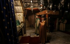 Members of the clergy pray inside the Grotto, believed to be the birthplace of Jesus Christ, in the Church of the Nativity in Bethlehem