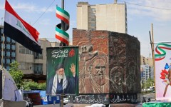 Commuters make their way past a picture of Iran's slain supreme leader Ayatollah Ali Khamenei (L) and a sculpture of late supreme leader Ayatollah Ruhollah Khomeini in Tehran