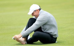 Second-ranked Rory McIlroy of Northern Ireland checks on a blister on his right pinky toe on the 18th hole during a practice round on the eve of the opening round of the PGA Championship at Aronimink
