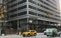 Cars drive past 77 Water Street, a former office building being transformed into luxury rental apartments in the Financial District of New York in April 2026