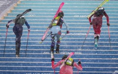 Competitors race uphill in a women's sprint ski mountaineering heat during the Milano Cortina 2026 Winter Olympic Games
