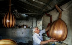 Displaced Palestinian craftsman Suhail Abu Shawish repairs damaged Ouds at a workship in Nuseirat refugee camp in Gaza