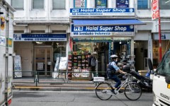 A police officer bikes past a convenience store in the Okubo–Shin area in Tokyo, a neighbourhood known for its large immigrant communities