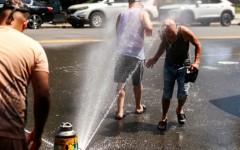 Men cool off at a fire hydrant in the Hamilton Heights neighborhood in Manhattan