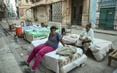 Sleeping out in the stifling summer heat leaves residents of a partially collapsed building exhausted