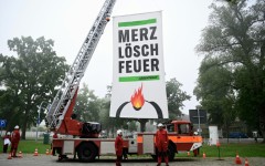 Greenpeace activists near the cabinet retreat set up a fire engine with a banner demanding: 'Merz, extinguish the fire'