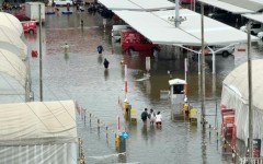 Pedestrians wade through flooded Bangkok roads after days of rain